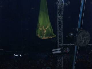 Воздушный акробат в сетке под куполом цирка